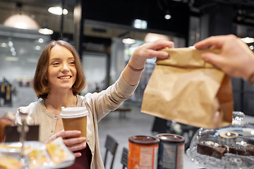 Image showing woman taking paper bag from seller at cafe