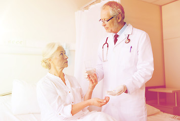 Image showing doctor giving medicine to senior woman at hospital