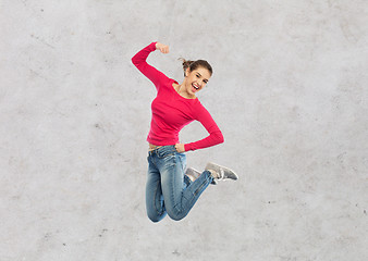 Image showing smiling young woman jumping in air