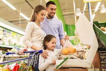 Image showing family weighing oranges on scale at grocery store