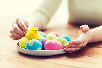 Image showing close up of woman hands with colored easter eggs