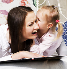 Image showing mother with daughter together in bed smiling, happy family close up, lifestyle people concept, cool real modern family playing