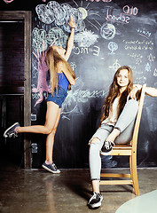 Image showing back to school after summer vacations, two teen girls in classroom with blackboard painted together