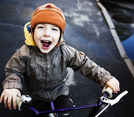 Image showing little cute real boy on bicycle smiling close up emotional posing autumn street, lifestyle people concept