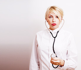 Image showing young pretty woman doctor with stethoscope emotional posing, pointing in camers, lifestyle people concept 