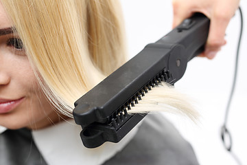 Image showing Straightening. Iron barbershops, hair straightening. Keratin hair straightening.