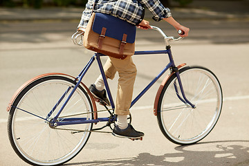 Image showing young hipster man with bag riding fixed gear bike