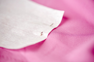 Image showing paper pattern attached with sewing pin to cloth