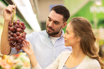 Image showing happy couple buying grapes at grocery store