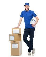 Image showing happy delivery man with parcel boxes and clipboard