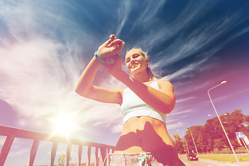 Image showing happy woman with heart rate watch and earphones