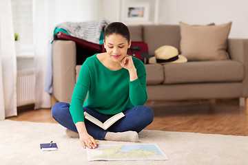 Image showing woman with notebook and travel map at home