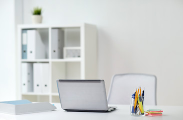 Image showing laptop with pen and stickers on office table