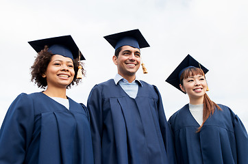 Image showing happy students or bachelors in mortarboards