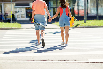 Image showing teenage couple with skateboards at city crosswalk