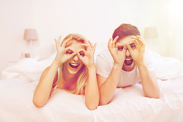 Image showing happy couple lying in bed at home