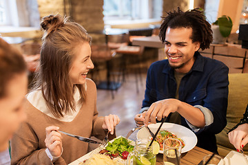 Image showing happy friends eating and drinking at restaurant