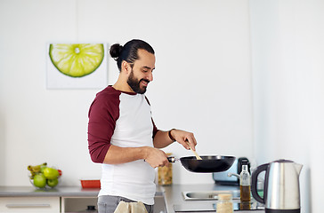 Image showing man with frying pan cooking food at home kitchen