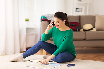 Image showing woman with travel map calling on smartphone