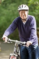 Image showing Senior asian biking