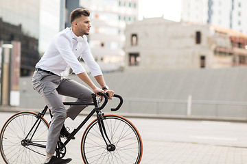 Image showing man with headphones riding bicycle on city street