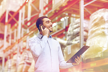 Image showing man with clipboard and smartphone at warehouse