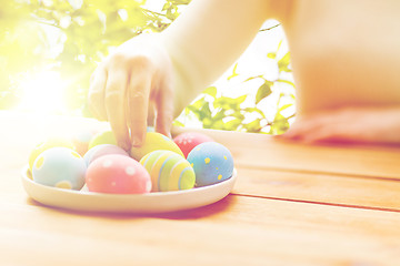 Image showing close up of woman hands with colored easter eggs