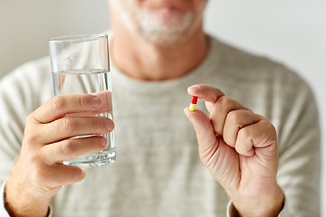 Image showing close up of hands with medicine pills and water