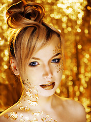 Image showing beauty blond woman with gold creative make up, bokeh on yellow background 