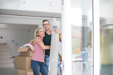 Image showing couple carrying a carpet moving in to new home