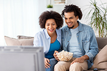 Image showing smiling couple with popcorn watching tv at home