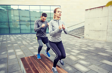 Image showing couple making step exercise on city street bench