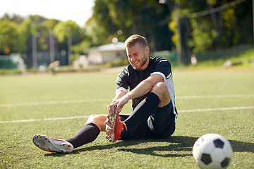 Image showing injured soccer player with ball on football field