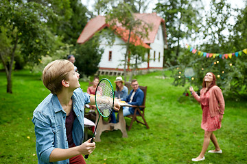 Image showing happy friends playing badminton at summer garden