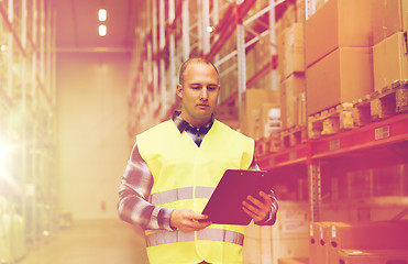 Image showing man with clipboard in safety vest at warehouse