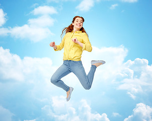 Image showing smiling young woman jumping in air