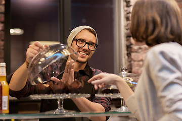 Image showing man or barman with cakes serving customer at cafe