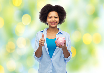 Image showing happy woman with piggy bank showing thumbs up