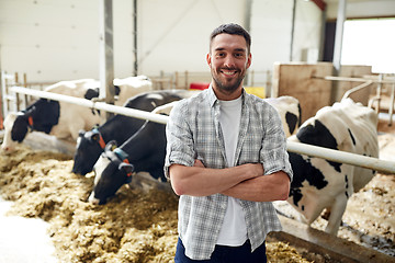 Image showing man or farmer with cows in cowshed on dairy farm