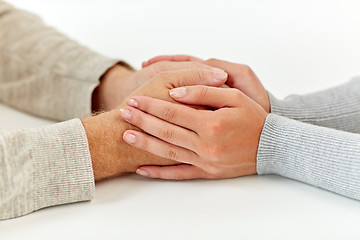 Image showing close up of old man and young woman holding hands