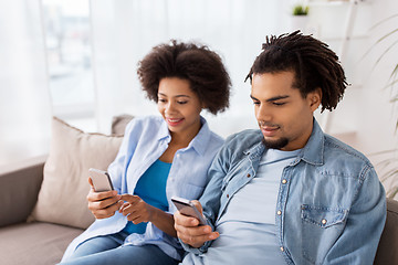 Image showing happy couple with smartphones at home