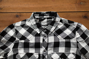 Image showing close up of checkered shirt on wooden background