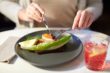 Image showing woman eating caviar toast skagen at restaurant