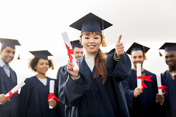 Image showing happy students with diplomas showing thumbs up