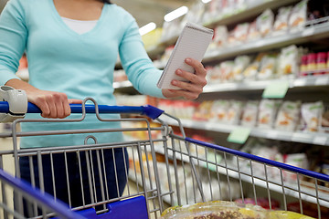 Image showing woman with food in shopping cart at supermarket