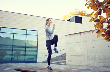 Image showing happy woman exercising on bench outdoors