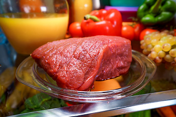 Image showing Fresh raw meat on a shelf open refrigerator