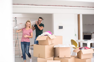 Image showing couple carrying a carpet moving in to new home