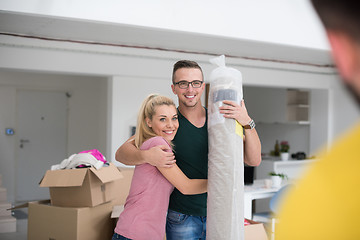 Image showing couple carrying a carpet moving in to new home