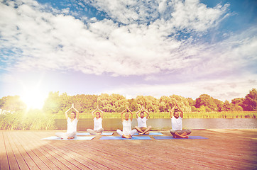 Image showing close up of people making yoga exercises outdoors